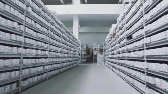明亮的仓库货架上摆满了带数字标记的白色盒子视频的预览图