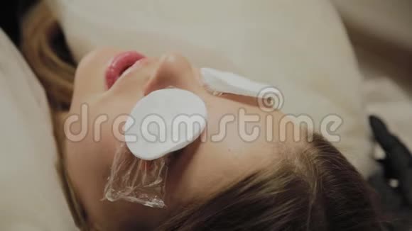 一个非常漂亮的女孩在美容院做一个层叠睫毛等待睫毛上的胶水干燥视频的预览图