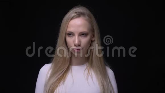 特写照片年轻漂亮的金发女性在镜头前看和摆姿势背景被隔离在视频的预览图
