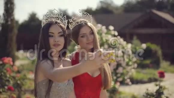 两个穿着晚礼服和皇冠的迷人女孩视频的预览图