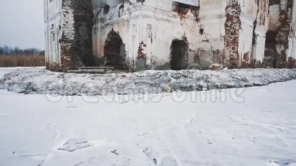 冰雪覆盖的冰冻湖中央废弃的大教堂建筑视频的预览图