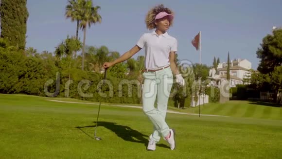 年轻漂亮的高尔夫球手拿着球摆姿势视频的预览图