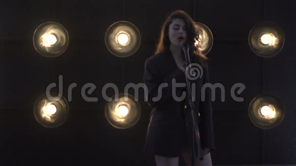 年轻漂亮的女孩唱歌年轻歌手唱成麦克风歌手的肖像特写视频的预览图