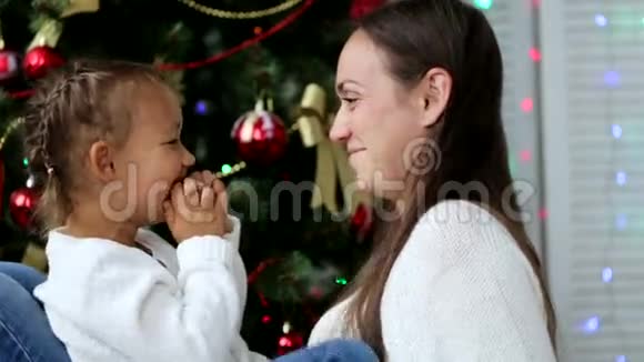 快乐的母亲在圣诞节的时候在圣诞树旁和孩子们玩得开心视频的预览图