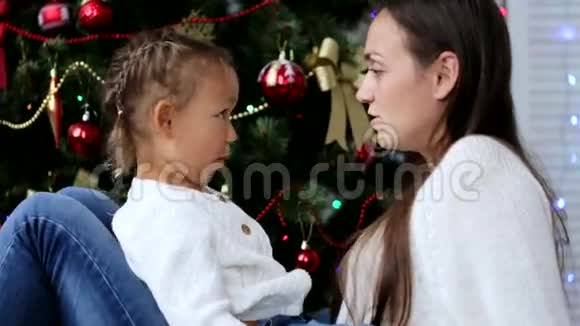 快乐的母亲在圣诞节的时候在圣诞树旁和孩子们玩得开心视频的预览图