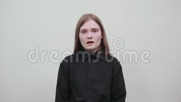 失望的年轻女子穿着黑色衬衫展开双手视频的预览图