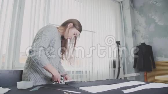 一位年轻女士在一个小设计工作室用剪刀剪布视频的预览图
