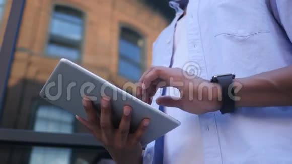 在线阅读平板电脑站立年轻黑人男性设计师视频的预览图