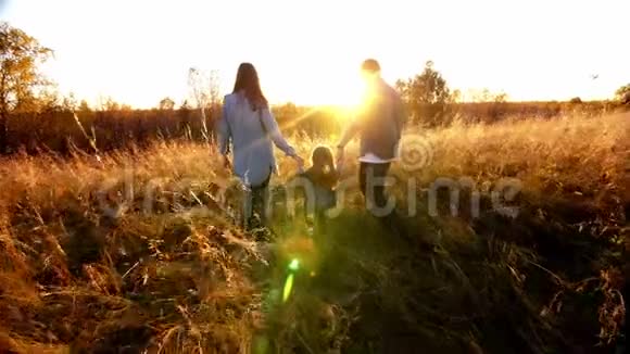 幸福的家庭父亲母亲女儿在大自然日落视频的预览图