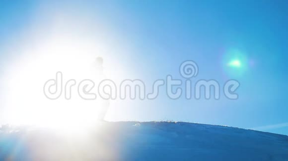 男子旅行者在冬季登山剪影阳光慢动作视频旅行冒险冬天的雪视频的预览图