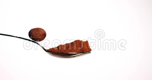 肉豆蔻肉豆蔻粉白色背景下落在肉豆蔻粉上的坚果慢动作视频的预览图