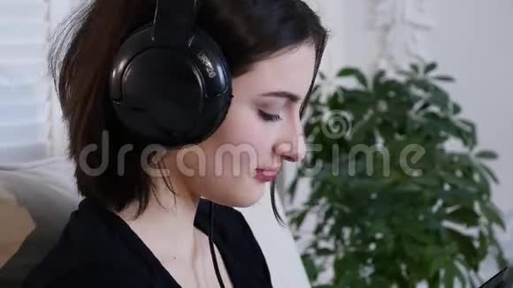 女性用耳机唱歌和听音乐视频的预览图