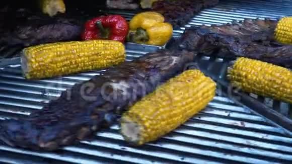 烤烧烤炉上的羊肉排骨和蔬菜烤肉和玉米慢动作视频的预览图