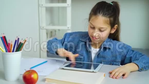 小女孩在网上玩游戏时触摸平板电脑屏幕视频的预览图