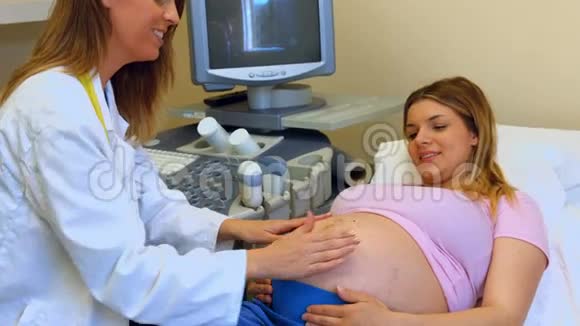 医生用手按着怀孕的女人的胃视频的预览图