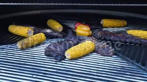 旋转烤架上的羊排和蔬菜烤肉和玉米慢动作视频的预览图