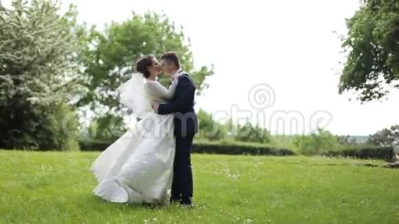 美丽的年轻夫妇新娘和新郎站在公园里视频的预览图