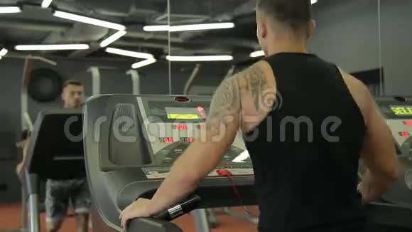 年轻的运动男女在运动健身房的跑步机上锻炼和跑步视频的预览图