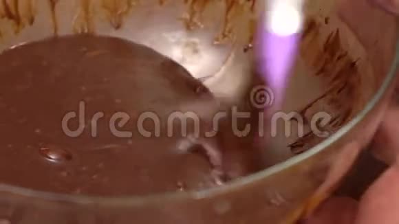 将融化的巧克力放入玻璃碗中搅拌然后用慢镜头拍摄视频的预览图