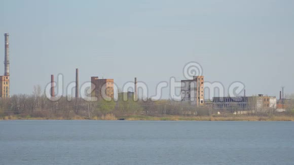 废弃的化工厂河岸上有烟囱视频的预览图