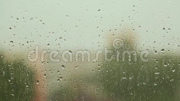 雨滴在雨天的玻璃窗户上流动视频的预览图
