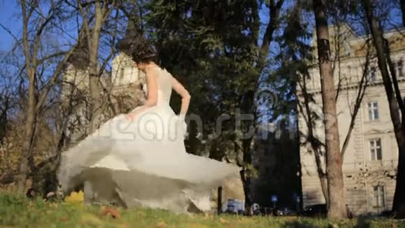 年轻美丽的新娘站在公园里游泳视频的预览图