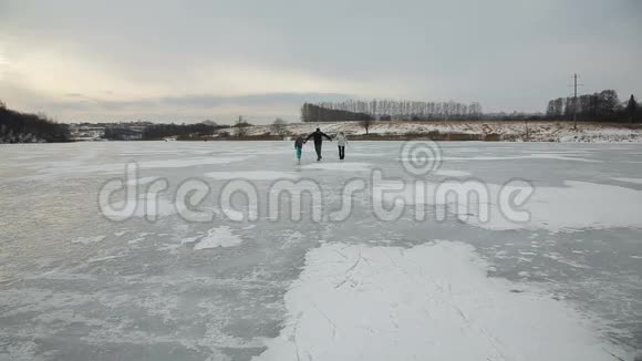 父亲带着女儿在冰冻的湖面上滑冰视频的预览图