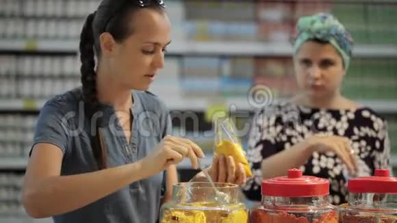 两位年轻的女士在超市的杂货店挑选香料视频的预览图