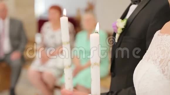 新婚夫妇在教堂里拿着蜡烛视频的预览图