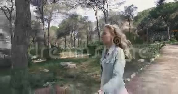 美丽的少女走过公园视频的预览图