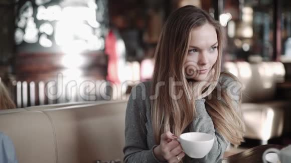 年轻迷人的女人在咖啡馆喝咖啡或茶Steadam射击视频的预览图