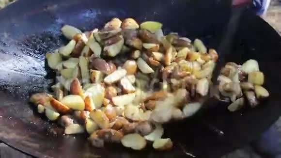 在街上篝火旁的大锅里煮土豆视频的预览图