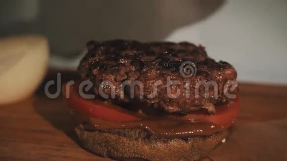 男厨师长白袍做汉堡包把洋葱放在烤肉上视频的预览图