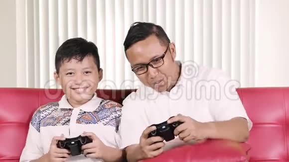 男孩和父亲玩电子游戏视频的预览图