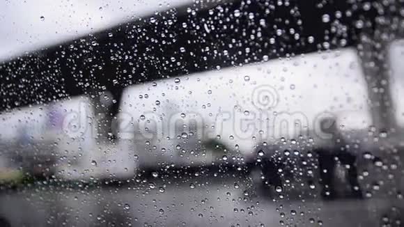 关上车窗玻璃上的雨滴和模糊的交通环境阴雨昏暗的背景视频的预览图