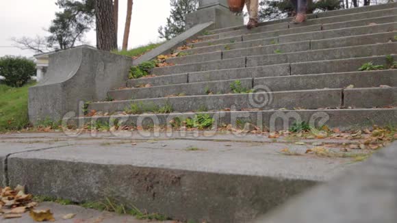 公园里的几个楼梯恋爱中的一对情侣在用石头做的楼梯上牵手年轻漂亮的一对视频的预览图