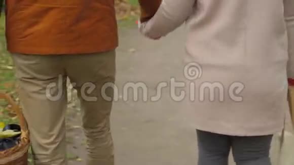 恋爱中的夫妻在公园里散步牵手情侣牵着手恋爱中的年轻情侣在户外散步视频的预览图