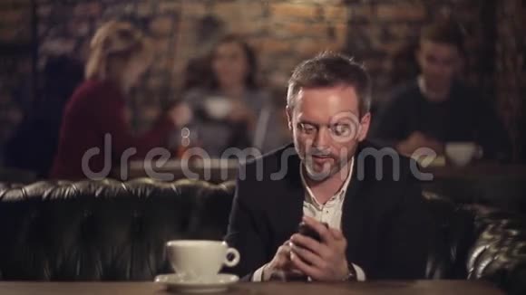 有智能手机的商人在咖啡厅喝咖啡视频的预览图