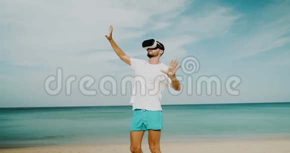 在海滩上戴虚拟现实眼镜的年轻人视频的预览图