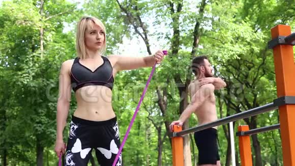 性感的金发女孩和男人正在户外公园训练前热身视频的预览图