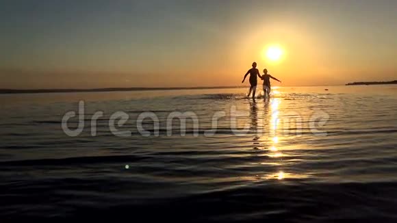 日落时分孩子们沿着水边奔跑视频的预览图