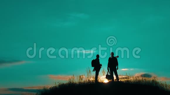 两男游客夜游人剪影去山夕阳游慢动作视频旅行成功的年轻人视频的预览图