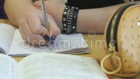 学习者用钢笔在练习本中写课文视频的预览图