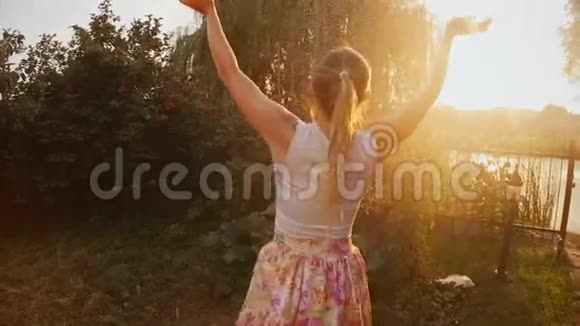 在花园水管溅起的水花下快乐的女人跳舞和欢笑的慢镜头视频的预览图