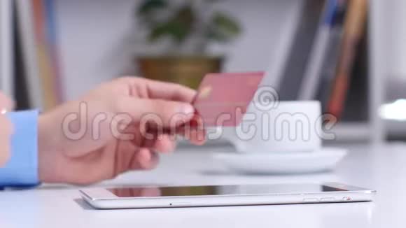 男士在线购物使用数字平板电脑和黄金信用卡关门视频的预览图