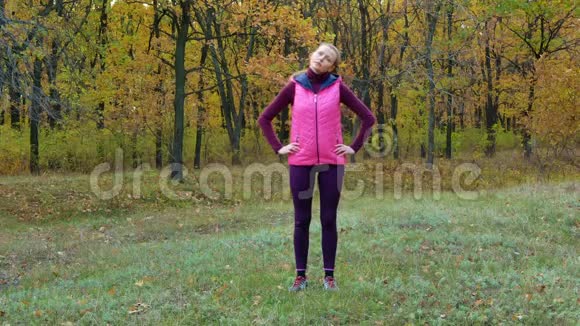 慢动作秋天穿着运动服的美丽的健身运动女孩从运动水瓶中喝水或等渗饮料视频的预览图