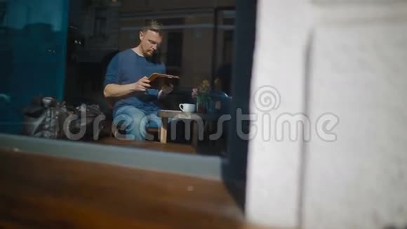 那人坐在自助餐厅的平板电脑旁工作视频的预览图