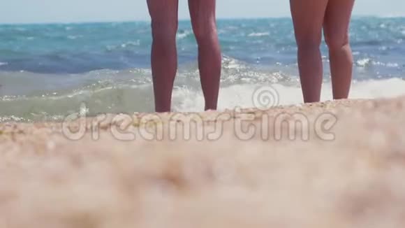 男人和女人站在海边的海滩上一对夫妇站在海滨脚上沾满了水夏季和视频的预览图