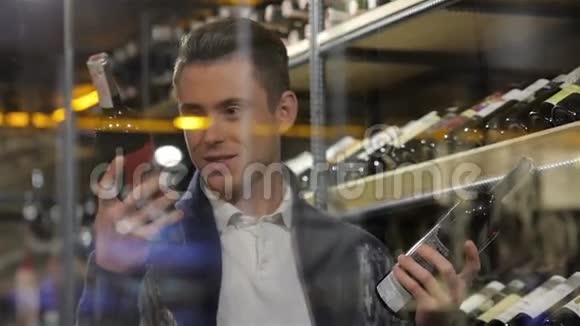 在超市里比较两种葡萄酒的男人视频的预览图