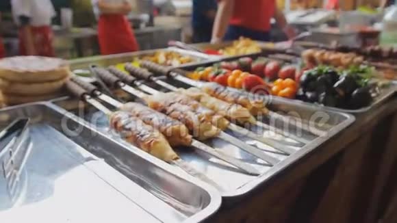 烤肉串上的烤肉在市场上烤鸡和蔬菜美食节锅上烤肉很多东西视频的预览图